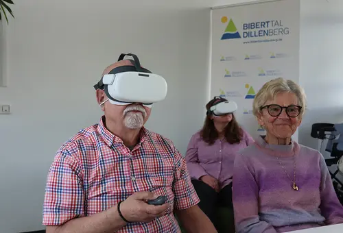 Ein Mann und eine Frau tragen eine VR-Brille, daneben eine weitere Frau.