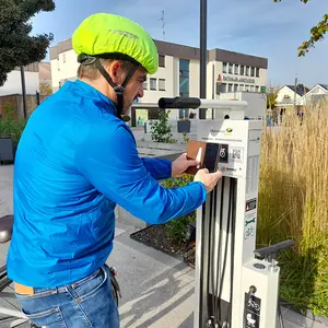 Ein Mann scannt den QR-Code an der Fahrrad-Reparaturstation