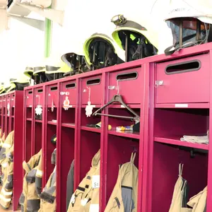 Offene Spinde im Gerätehaus mit Uniformen und Helmen