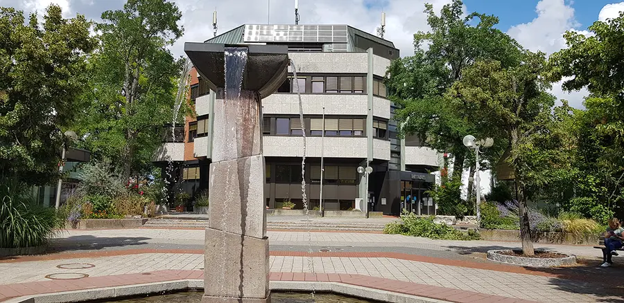 Brunnen im Vordergrund vor einem achteckigen Gebäude