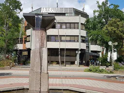 Brunnen im Vordergrund vor einem achteckigen Gebäude