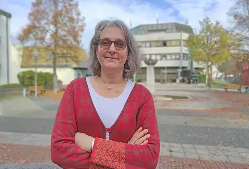Portrait lächelnde Frau mit Oberasbacher Rathaus im Hintergrund