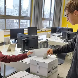 Ein junger Mann wirft seinen Stimmzettel in die Urne.