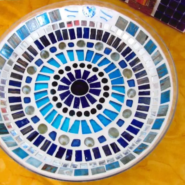 Eine runde Platte mit konzentrischem Mosaikmuster in Blautönen. 