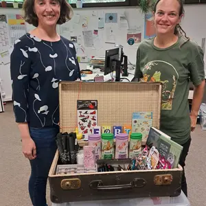 Zwei Frauen vor einem nostalgischen Koffer mit Präsenten 