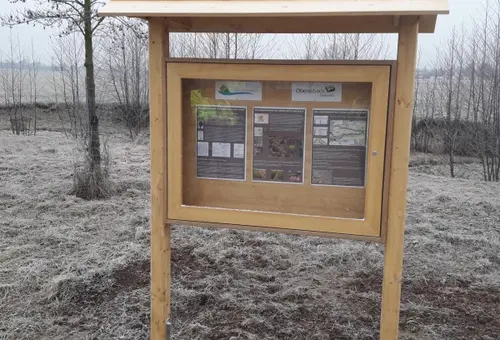 Ein Holzschaukasten mit Holzdach in freiem Gelände