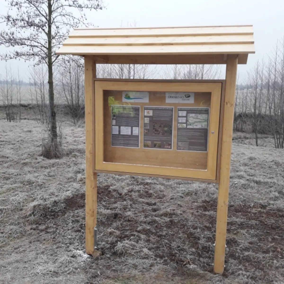 Ein Holzschaukasten mit Holzdach in freiem Gelände