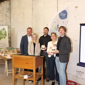 5 Personen, drei davon mit kleinen Geschenken in der Scheune.