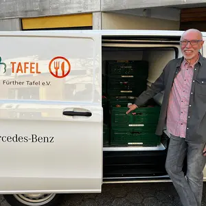 Ein Mann neben der geöffneten Transportertür.