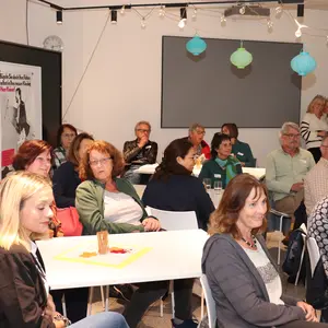Gruppe von Menschen an verschiedenen Tischen 