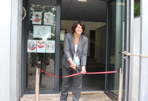 Erste Bürgermeisterin Birgit Huber durchschneidet symbolisch das rote Band vor der Eingangstür des Foyers