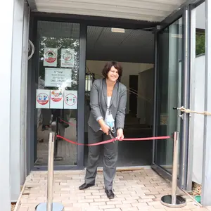 Erste Bürgermeisterin Birgit Huber durchschneidet symbolisch das rote Band vor der Eingangstür des Foyers