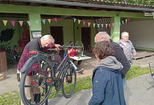Mann prüft Fahrrad auf Reparaturstand bei Fahrradnachbarschaftswerkstatt 