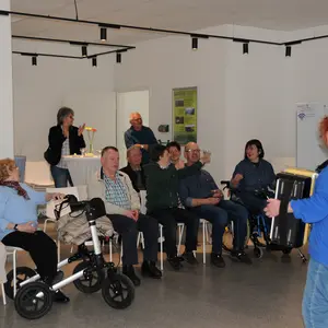 Akkordeonspielerin in Aktion vor den Mitgliedern des Behindertenclubs
