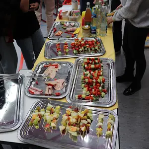 Blick auf die bereits weitgehend geleerten Platten des Büffets mit Obstspießen und Wurst.