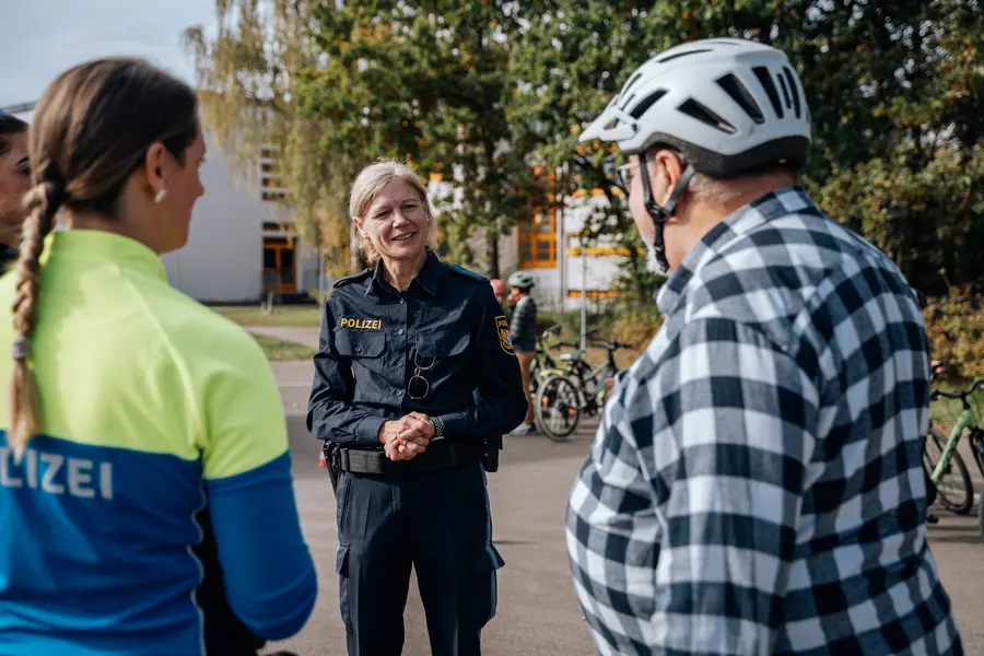 Zwei Polizeibeamtinnen im Gespräch mit einem Radfahrer 