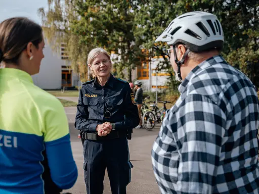 Zwei Polizeibeamtinnen im Gespräch mit einem Radfahrer 