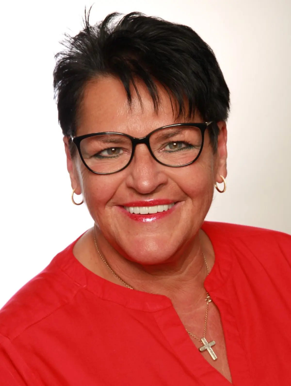 Frau mit kurzen dunklen Haaren und Brille und roter Bluse