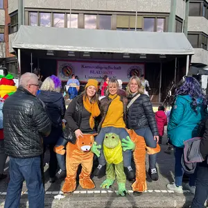 Drei Frauen in ihren Kostümen. Im Hintergrund ist die Bühne zu erkennen.