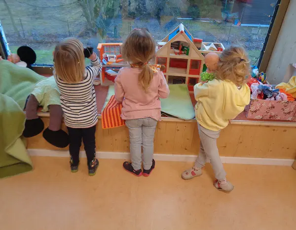Kinder spielen und schauen aus dem Fenster