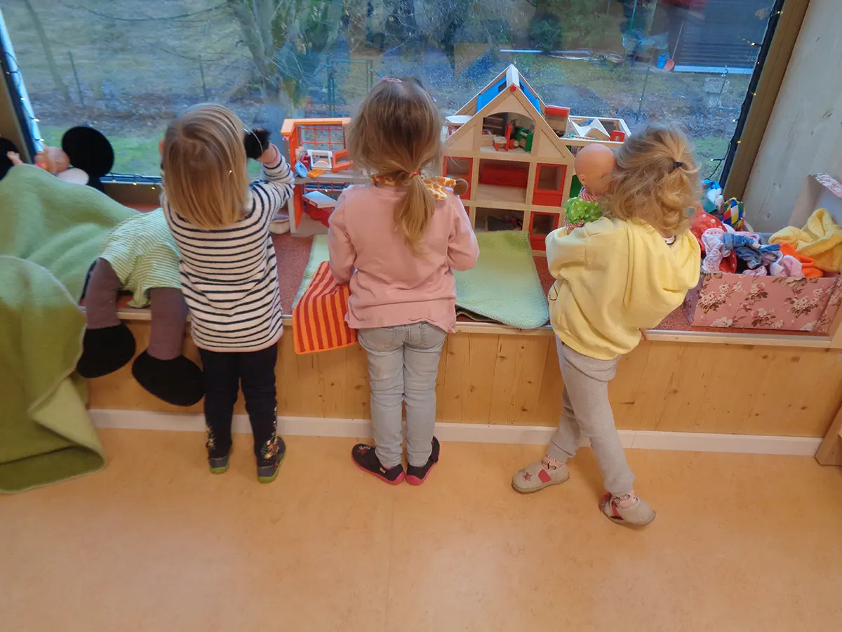 Kinder spielen und schauen aus dem Fenster