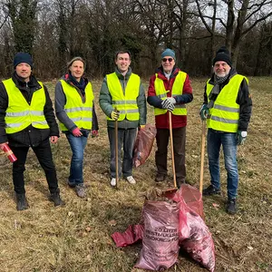 Männer und FRauen in Warnweste mit Müllsäcken