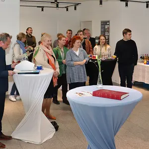 Zahlreiche Personen an Stehtischen.