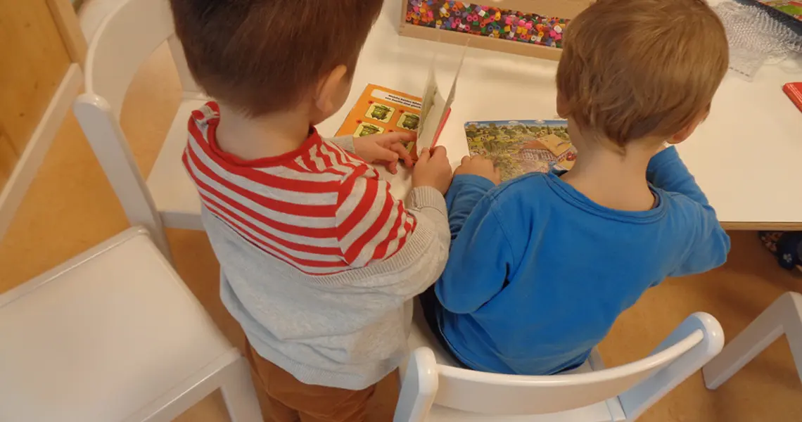 Kinder sind mit einem Buch beschäftigt