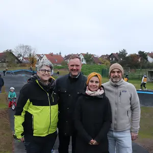 Zwei Männer und zwei Frauen beim Gruppenbild vor dem Pumptrack.