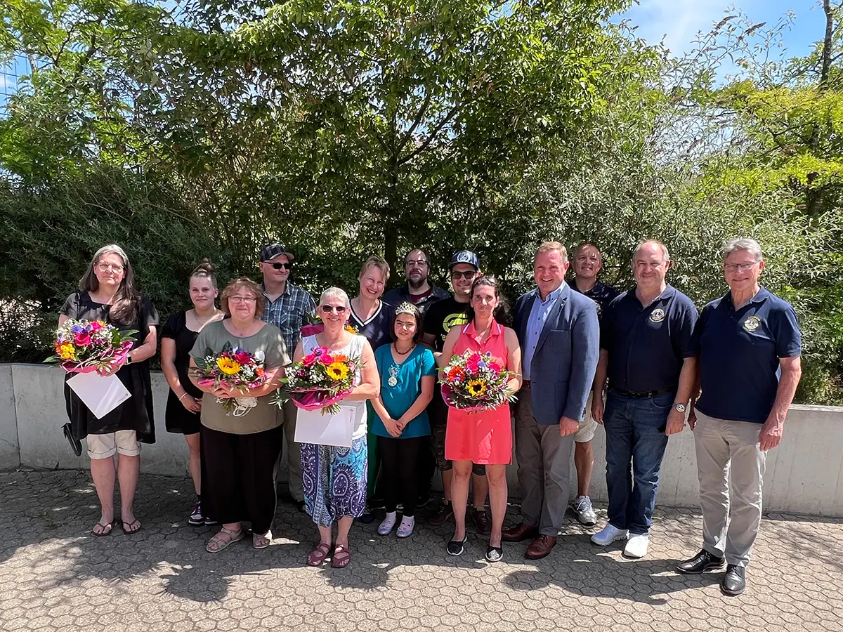 Gruppenbild mit rund zwölf Personen, die Frauen erhielten Blumensträuße