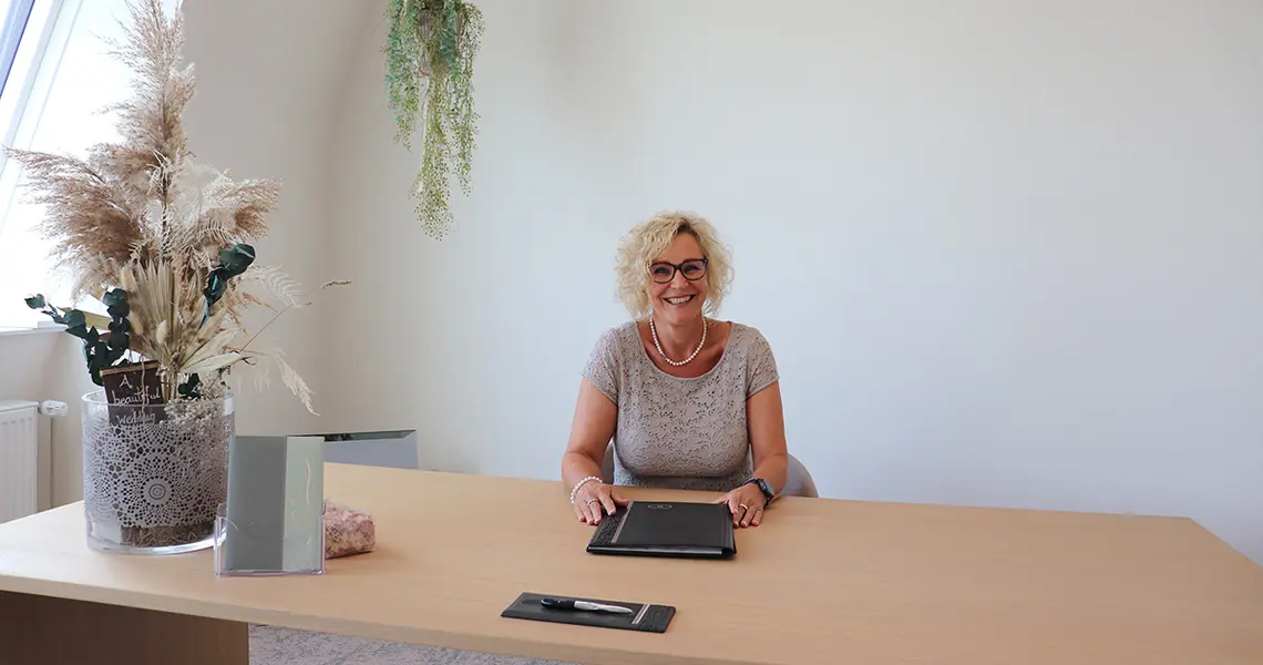 Die Standesbeamtim sitzt hinter dem großen Schreibtisch